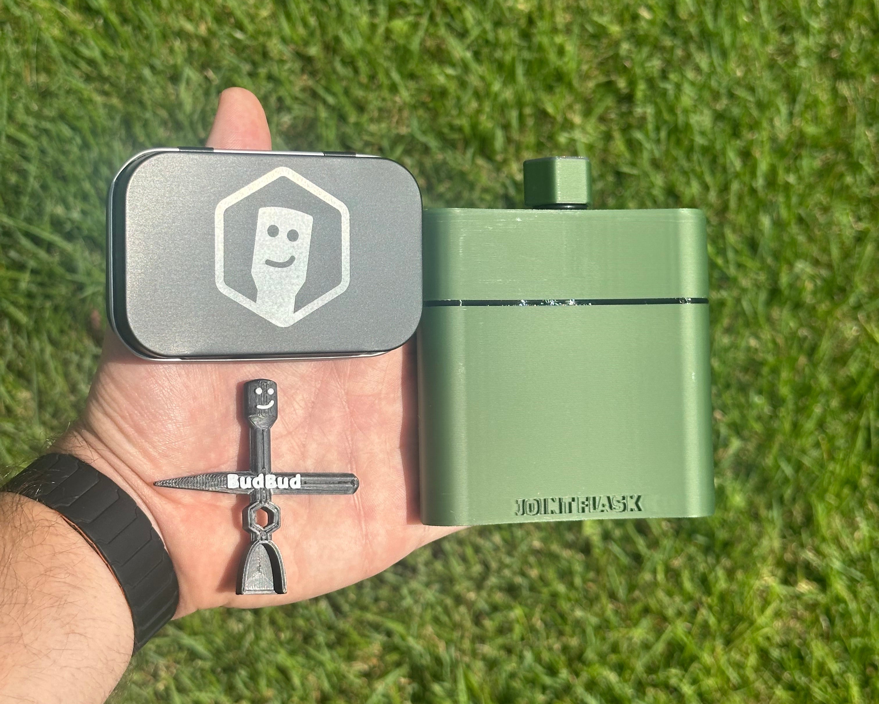 Hand holding a Joint Flask, BudBud Tool, and Happy Packing Tin