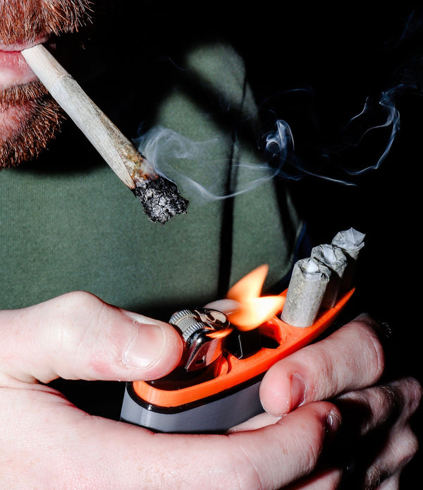 Person smoking joint holding lighter inside joint flask