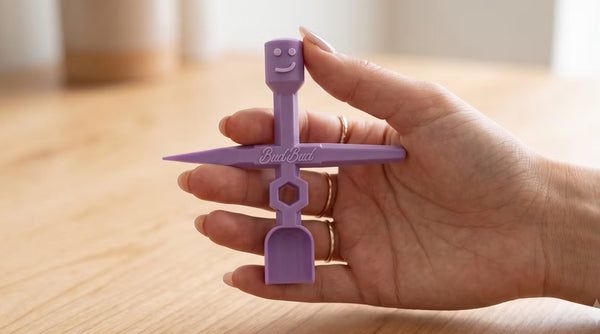 A hand holding a purple BudBud